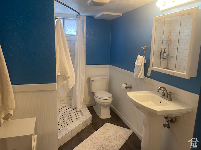 Bathroom featuring wainscoting and a tile shower