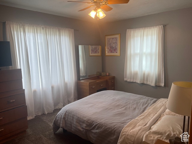 Bedroom featuring dark carpet and ceiling fan