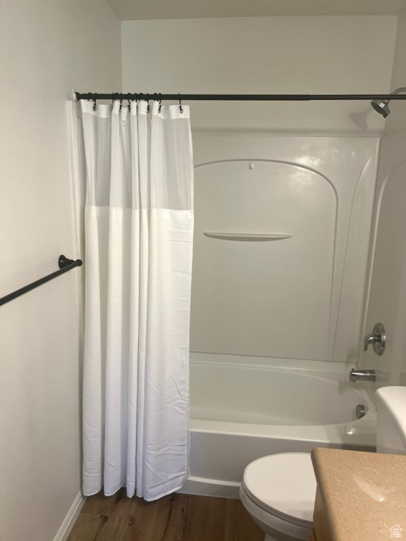 Bathroom featuring shower / tub combo, vanity, and wood finished floors