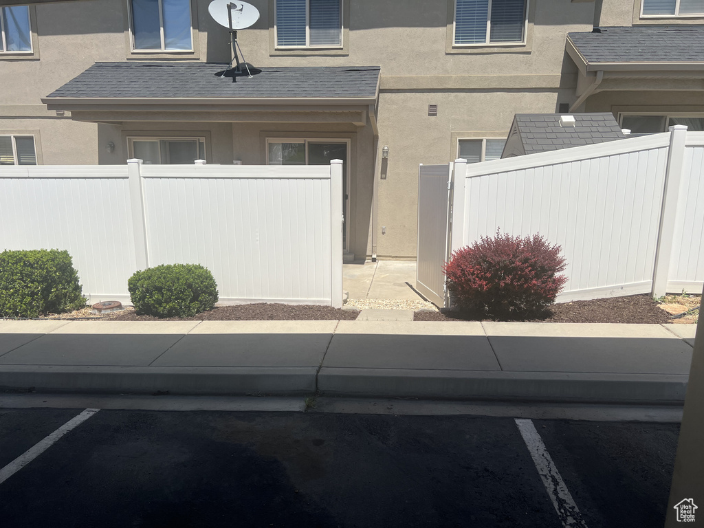 Entrance to property with stucco siding and uncovered parking