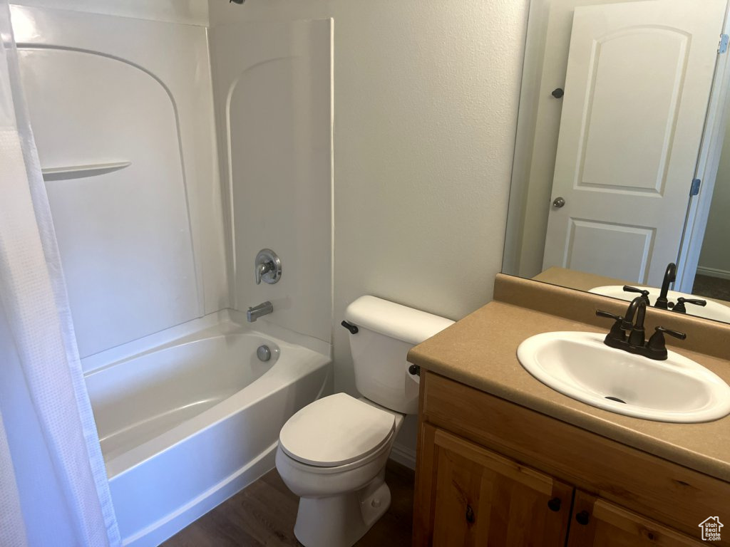 Full bathroom featuring vanity, shower / tub combo with curtain, and wood finished floors