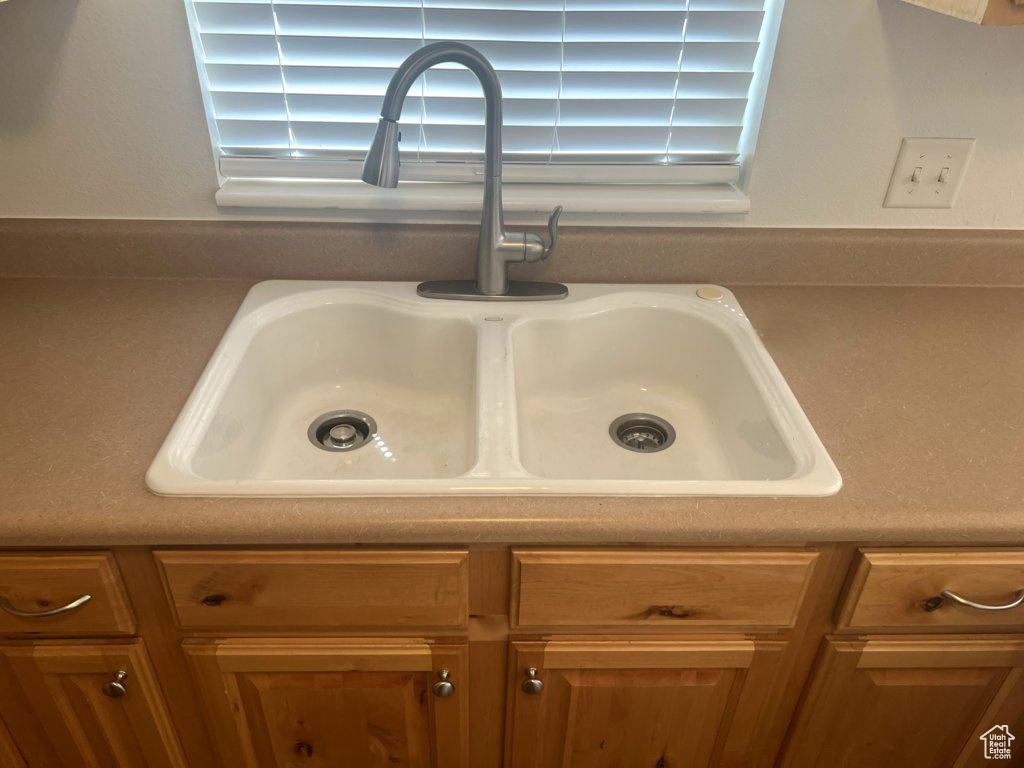 Kitchen view of a sink and brown cabinetry