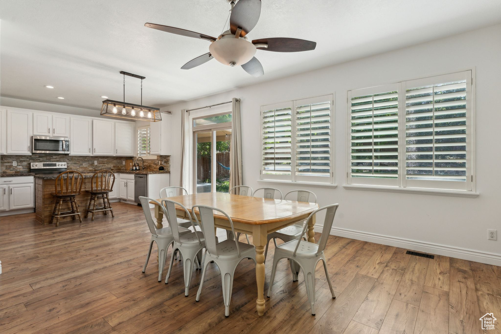 Dining space featuring ceiling fan, light wood-style floors, baseboards, and recessed lighting