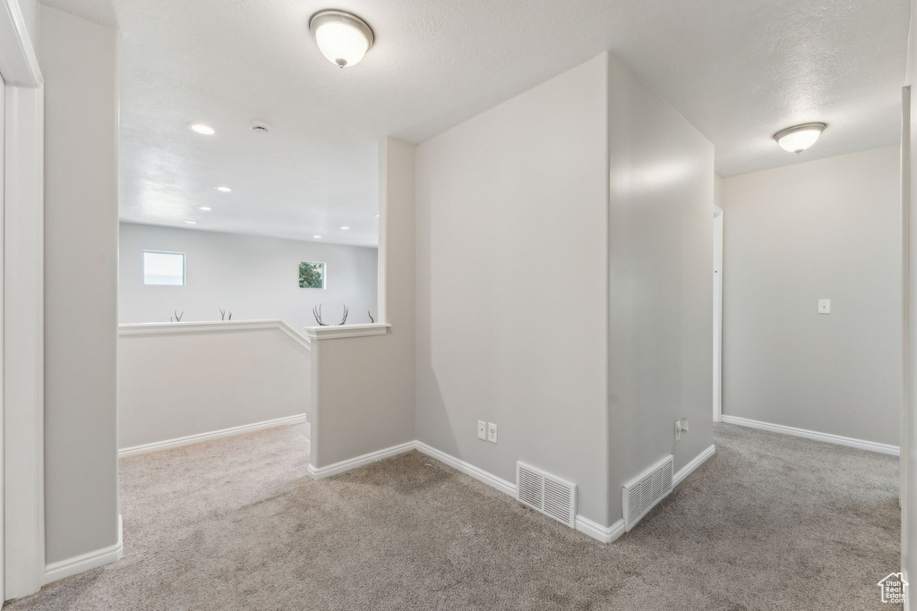 Carpeted spare room with baseboards and recessed lighting