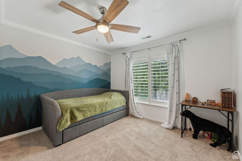 Carpeted bedroom with ornamental molding and ceiling fan