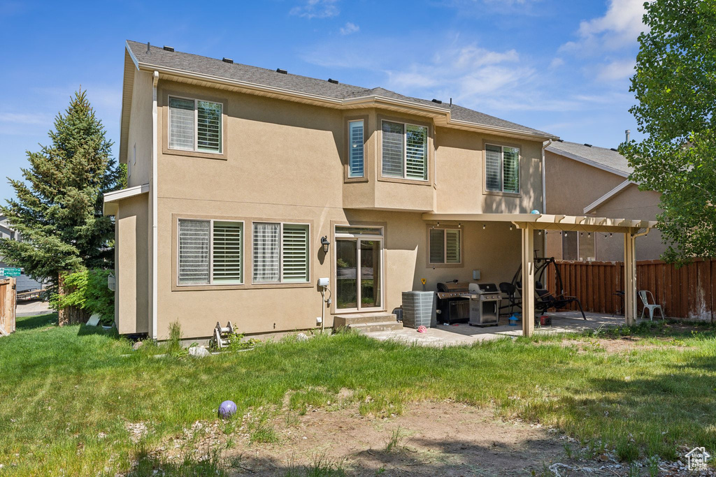 Rear view of property featuring stucco siding, entry steps, a patio area, and a pergola