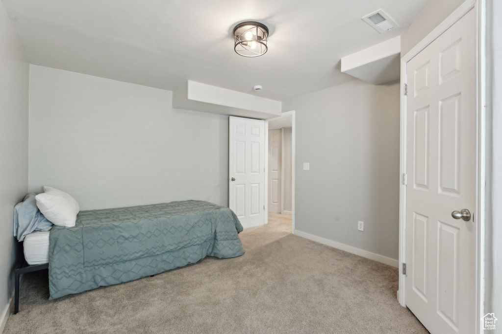 Bedroom with light carpet and baseboards