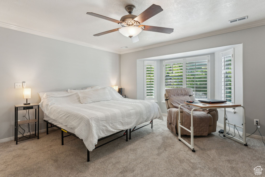Bedroom featuring baseboards, ornamental molding, carpet, and a ceiling fan