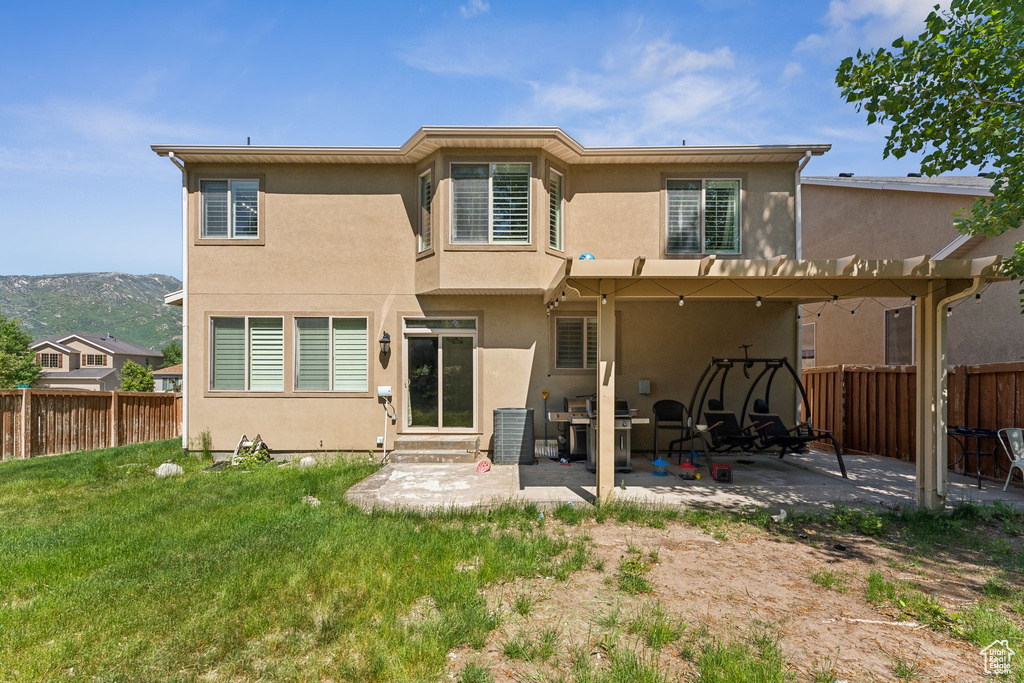 Rear view of house featuring stucco siding, a patio, entry steps, and a mountain view