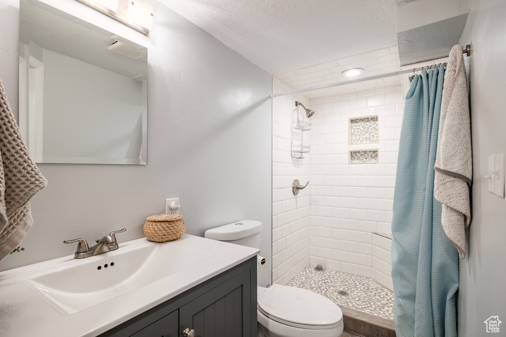 Full bathroom featuring tiled shower and vanity