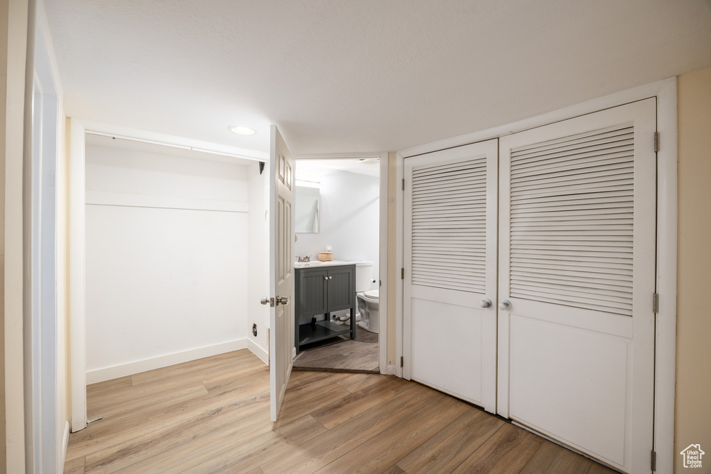 Unfurnished bedroom featuring light wood-type flooring, recessed lighting, connected bathroom, and a closet