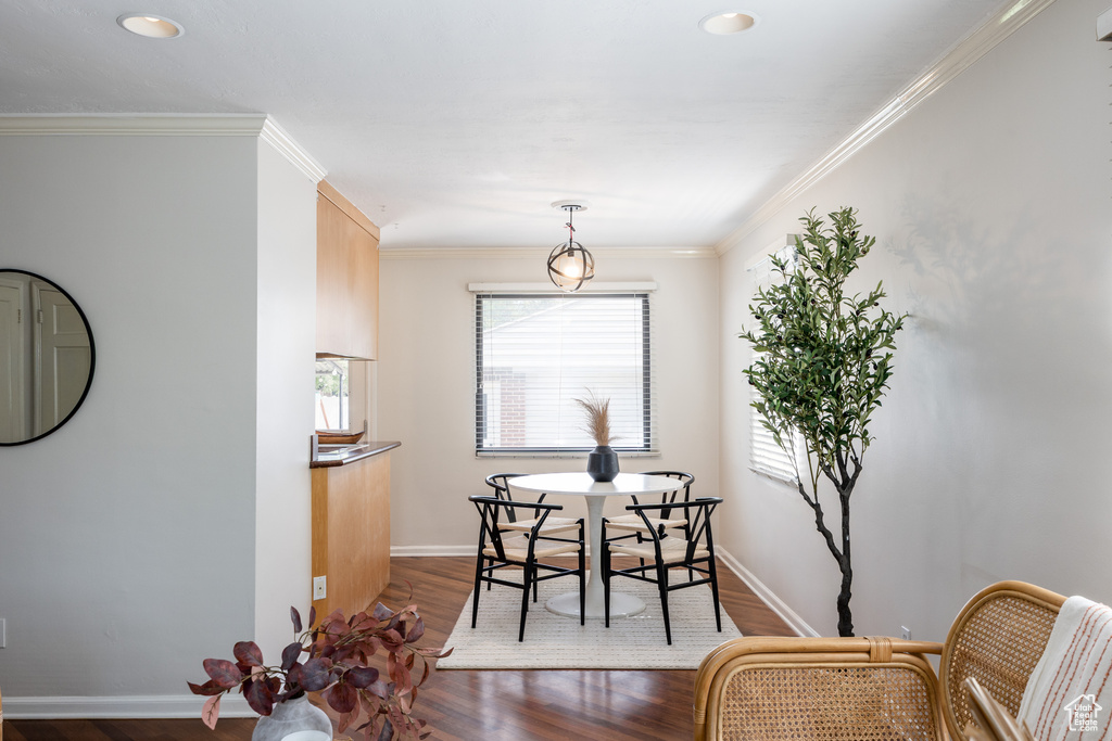Dining space featuring wood finished floors, crown molding, and recessed lighting