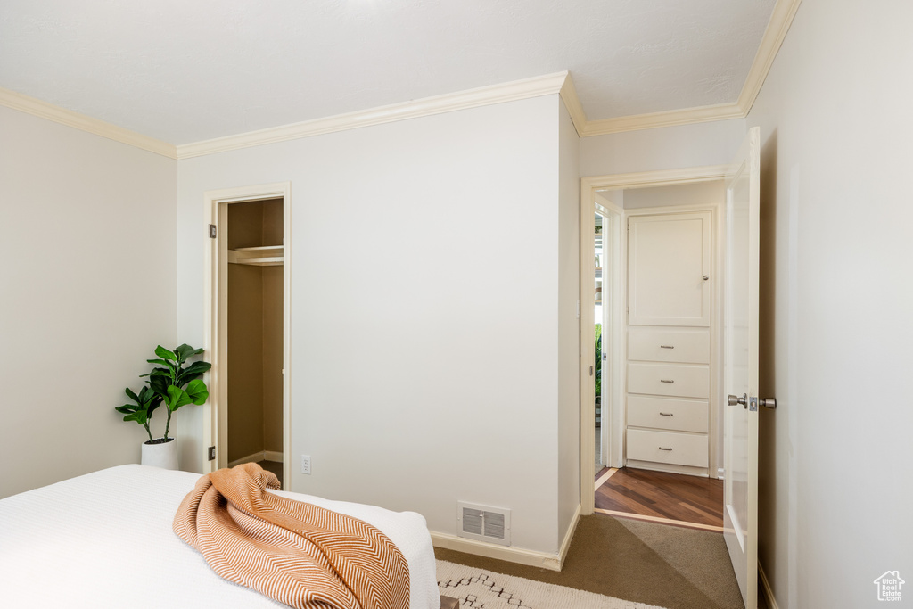 Bedroom with ornamental molding and carpet flooring