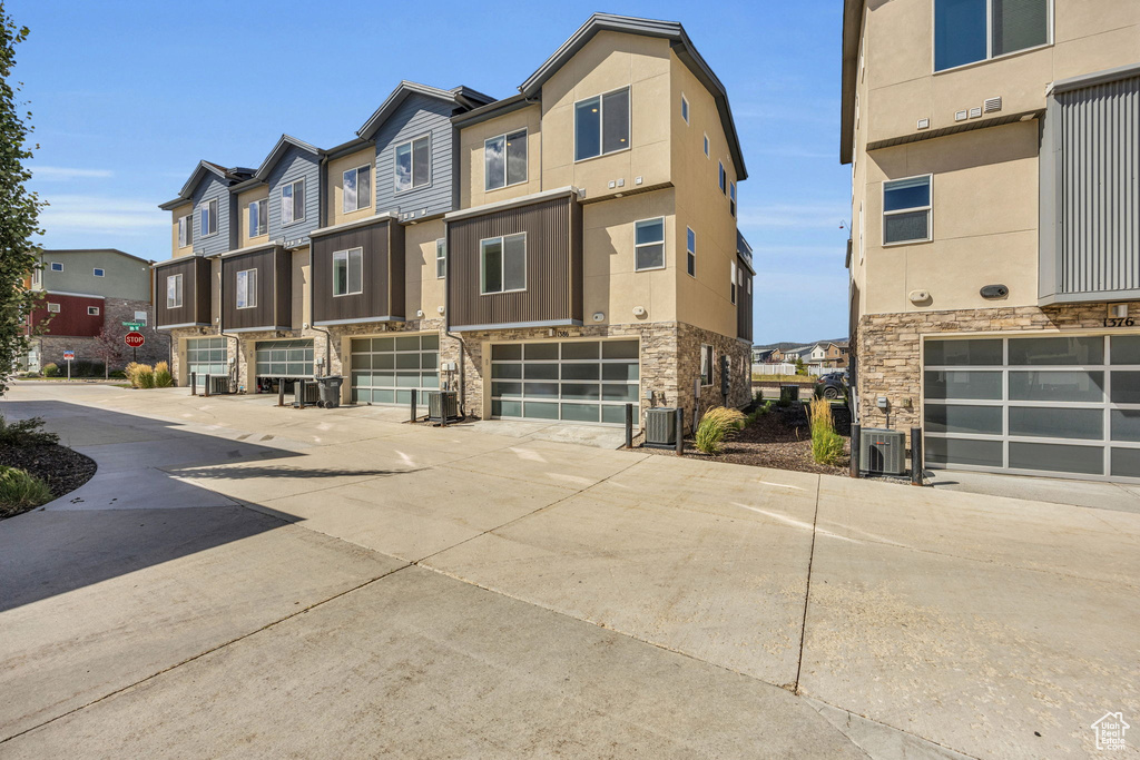 View of front of property with an attached garage, a residential view, and driveway