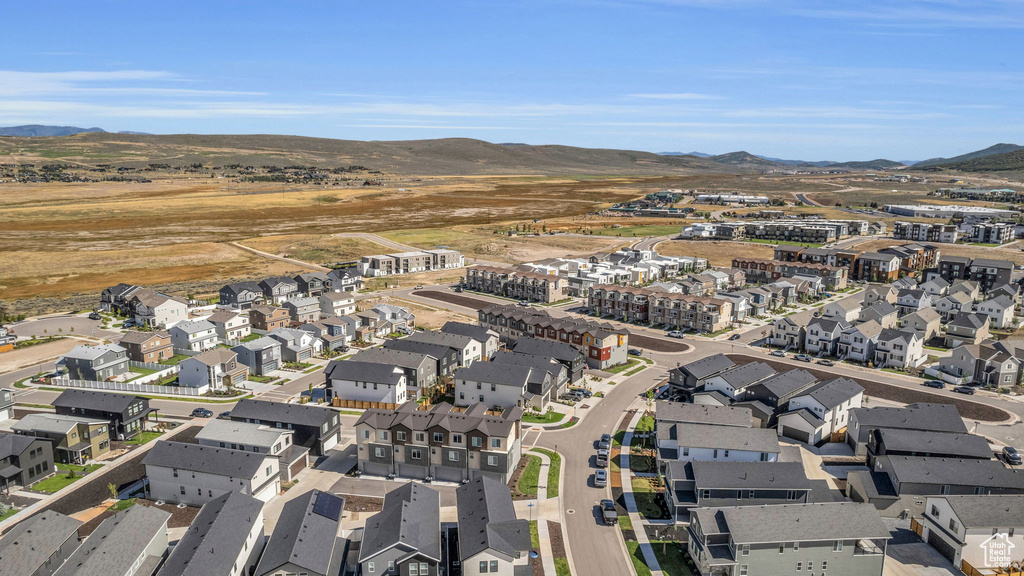 Aerial view of property and surrounding area with mountains and nearby suburban area