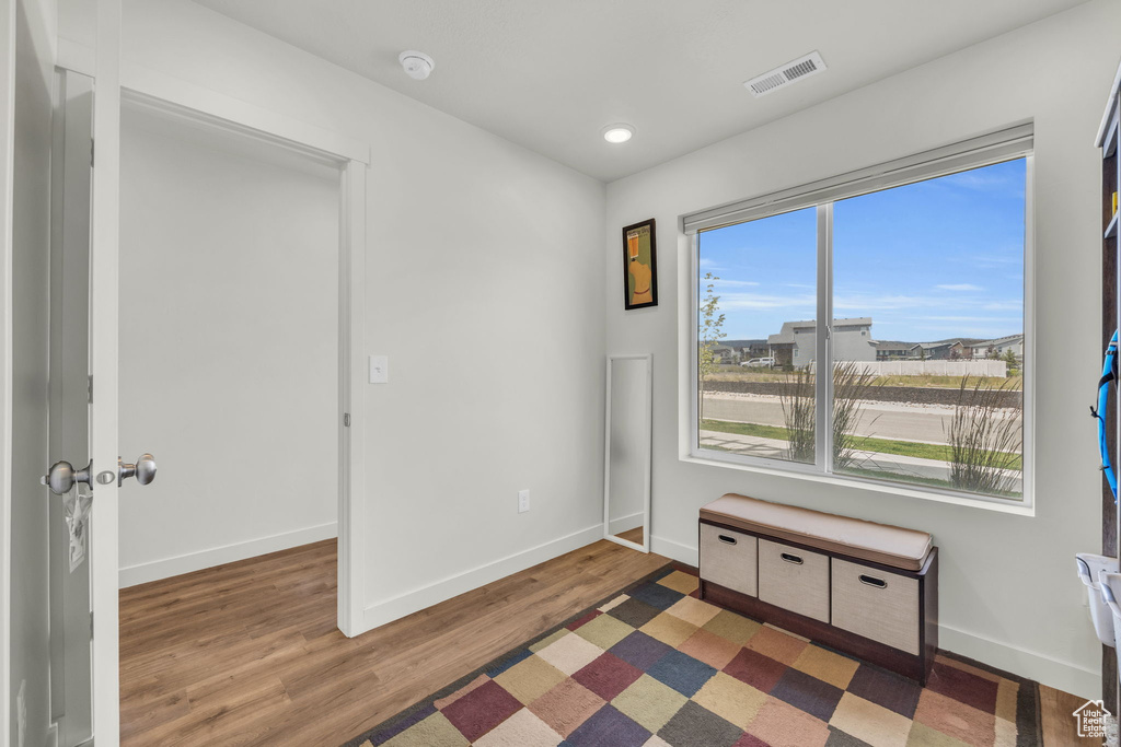 Empty room featuring wood finished floors, a smoke detector, and recessed lighting