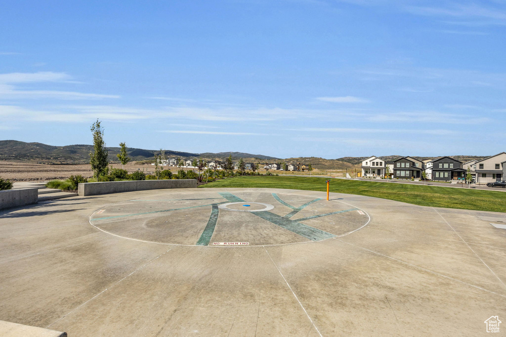 Surrounding community featuring a mountain view, community basketball court, and a lawn