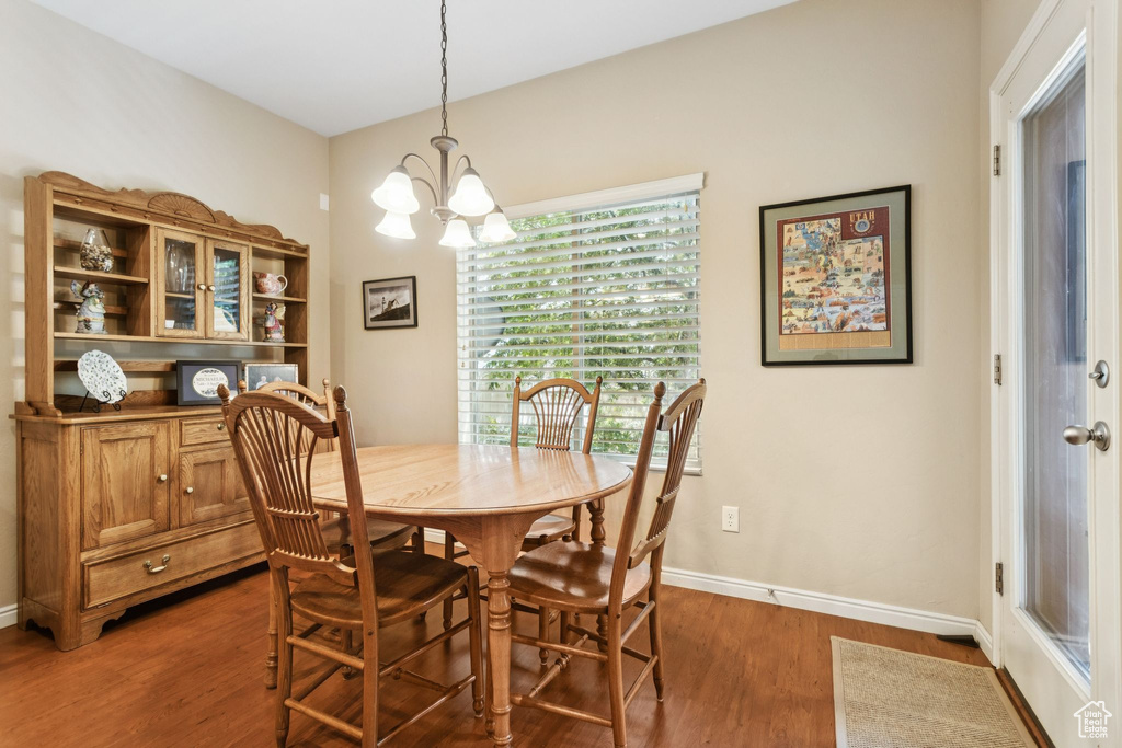Dining room with dark wood finished floors and a chandelier
