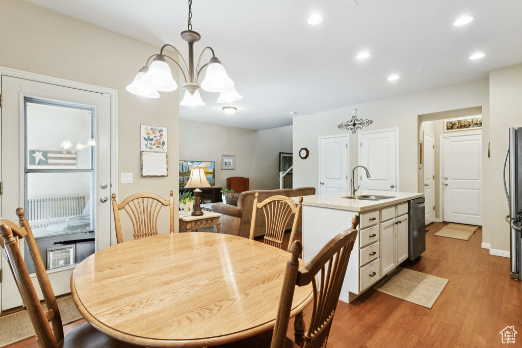 Dining area with wood finished floors, recessed lighting, and a chandelier