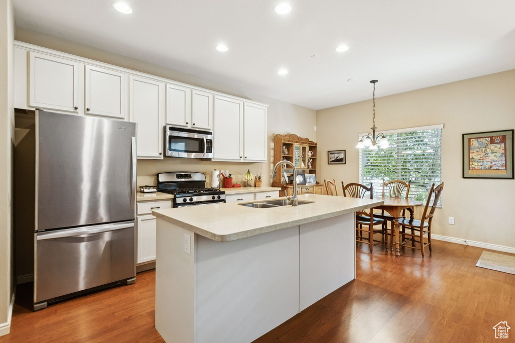 Kitchen with appliances with stainless steel finishes, light countertops, dark wood finished floors, white cabinetry, and recessed lighting