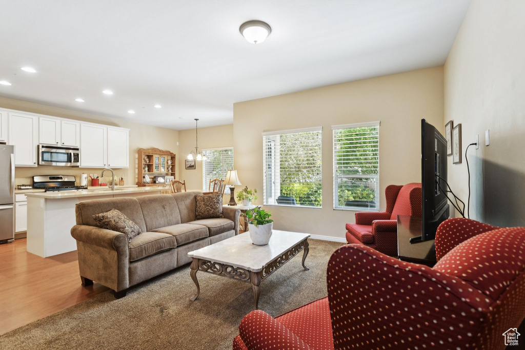 Living room featuring plenty of natural light, recessed lighting, a chandelier, light carpet, and light wood-style floors