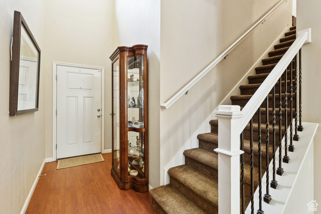 Stairway with wood finished floors and baseboards
