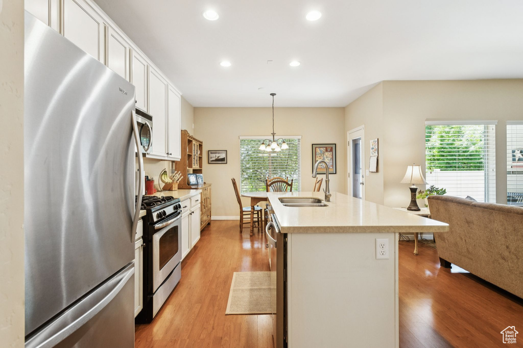 Kitchen featuring stainless steel appliances, recessed lighting, light wood-style flooring, plenty of natural light, and white cabinets