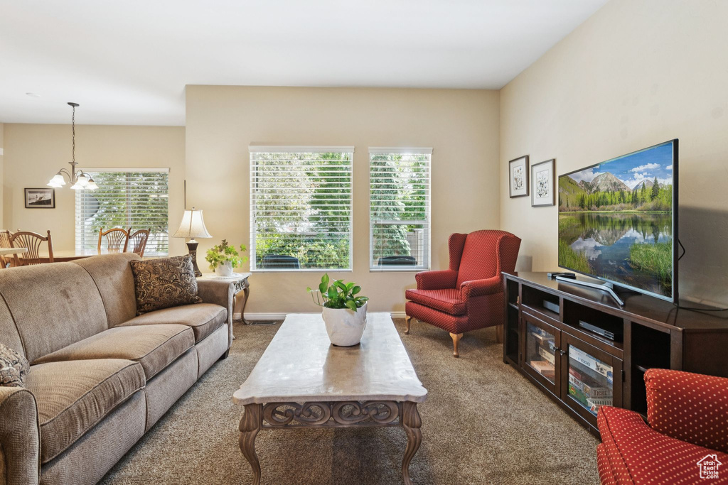 Carpeted living area featuring a chandelier