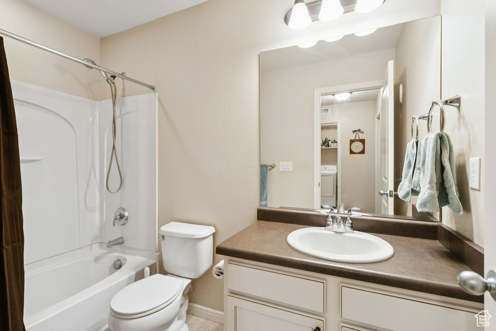 Full bathroom with vanity, shower / washtub combination, and washer / dryer