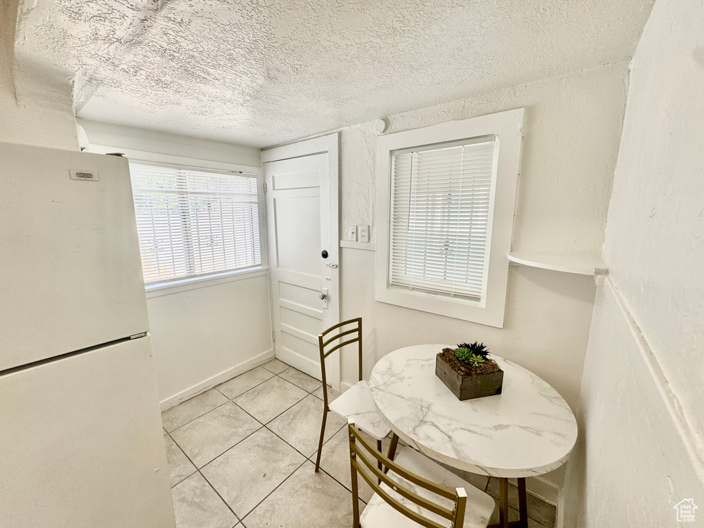 Dining room featuring a textured ceiling and light tile patterned flooring