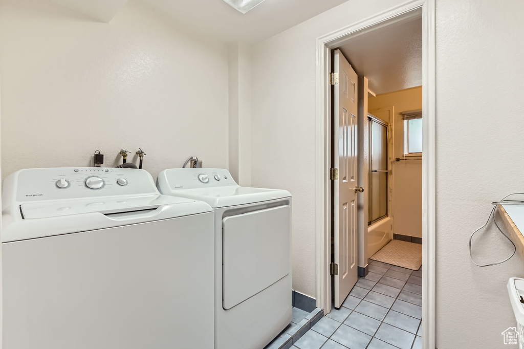 Washroom featuring separate washer and dryer and light tile patterned flooring
