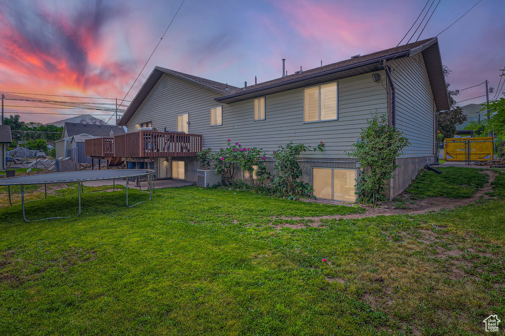Back of house featuring a trampoline and a deck