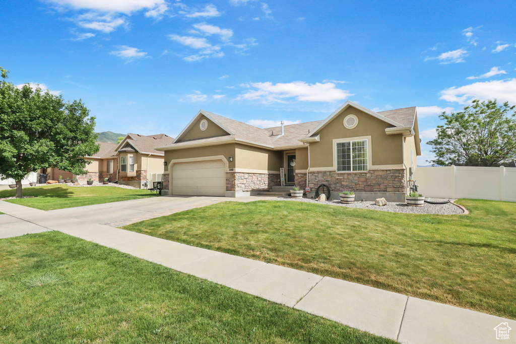 View of front of house featuring stucco siding, stone siding, a garage, and concrete driveway