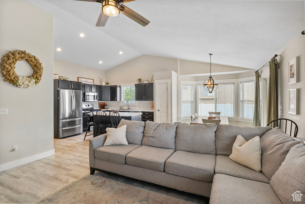 Living area featuring lofted ceiling, light wood-style floors, recessed lighting, and a ceiling fan