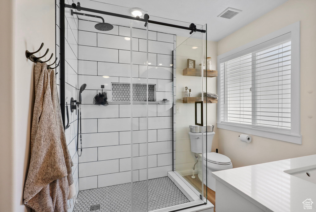 Bathroom featuring vanity, healthy amount of natural light, a shower stall, and tile patterned flooring