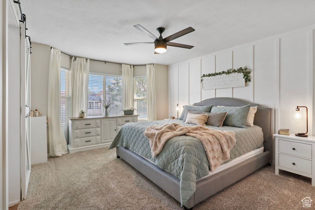 Bedroom featuring light colored carpet and a ceiling fan