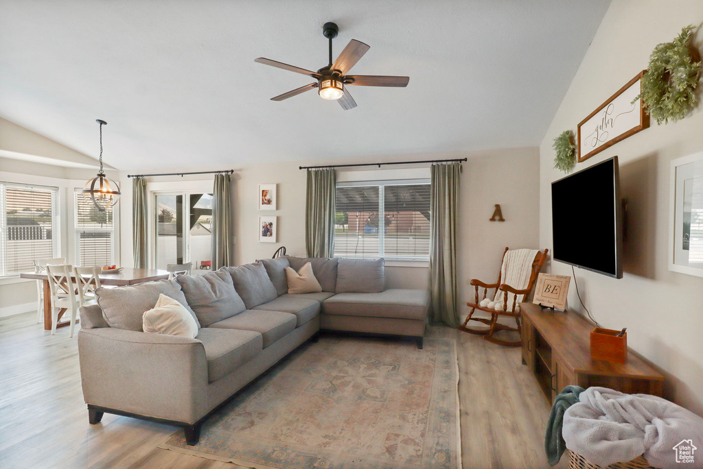 Living area featuring lofted ceiling, light wood finished floors, and a ceiling fan