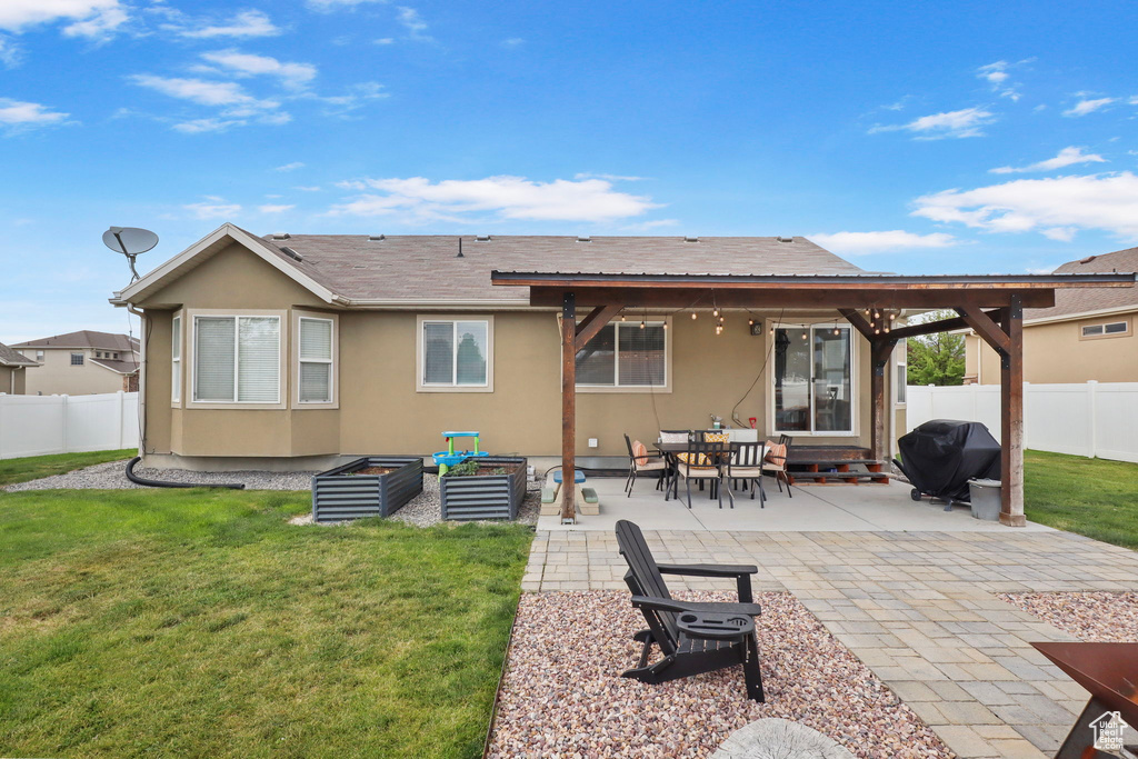 Back of house with a fenced backyard, a patio area, stucco siding, and roof with shingles