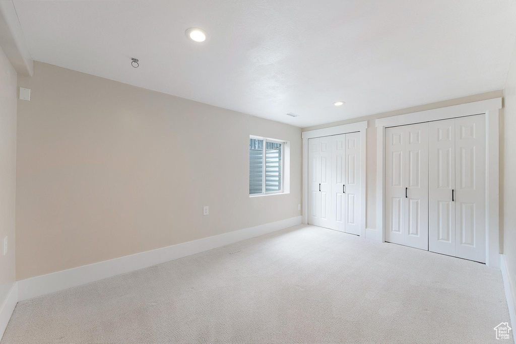 Unfurnished bedroom with multiple closets, carpet, and recessed lighting