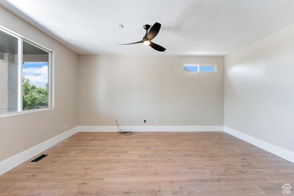 Empty room featuring ceiling fan and light wood-type flooring