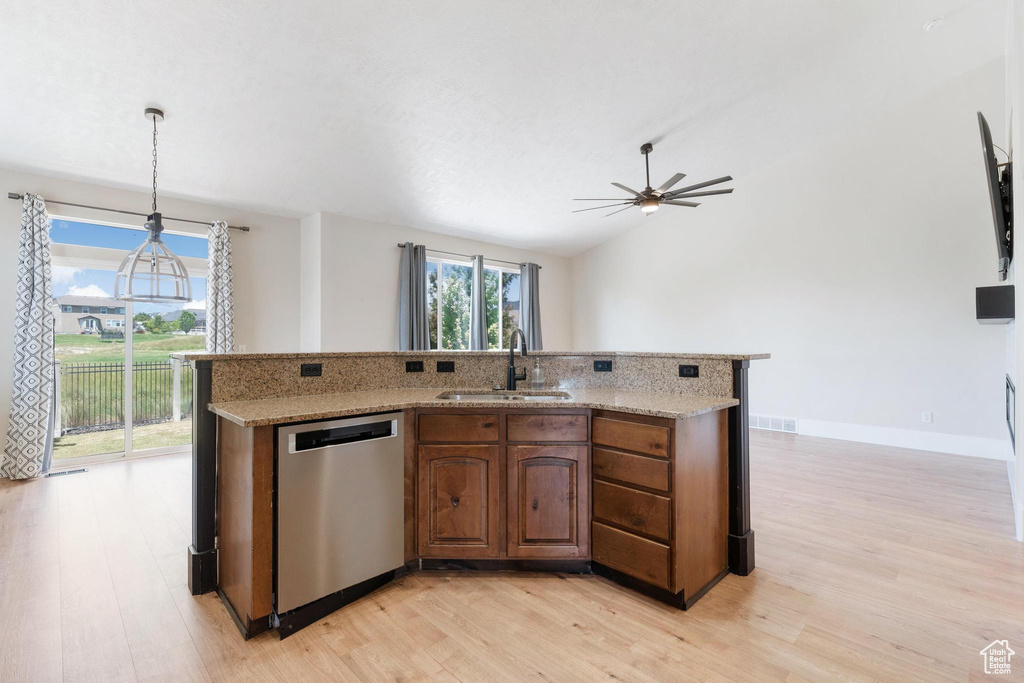 Kitchen with stainless steel dishwasher, light wood-type flooring, ceiling fan, light stone countertops, and lofted ceiling
