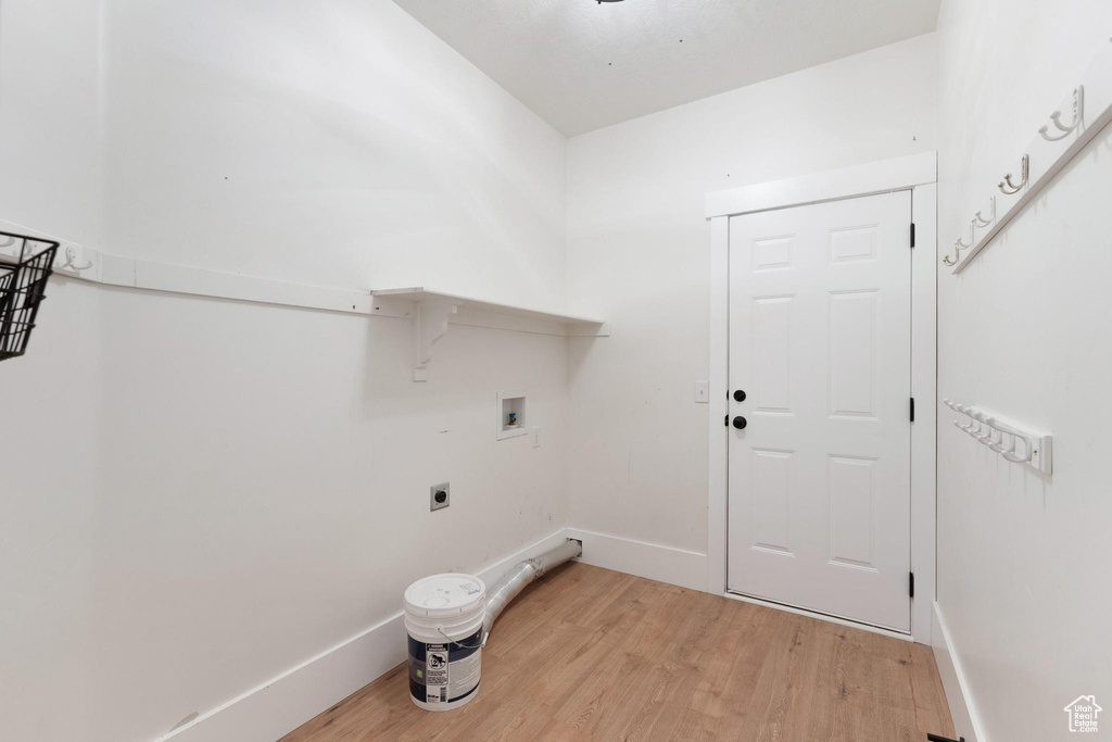 Laundry area featuring hookup for a washing machine, light wood-style flooring, and electric dryer hookup