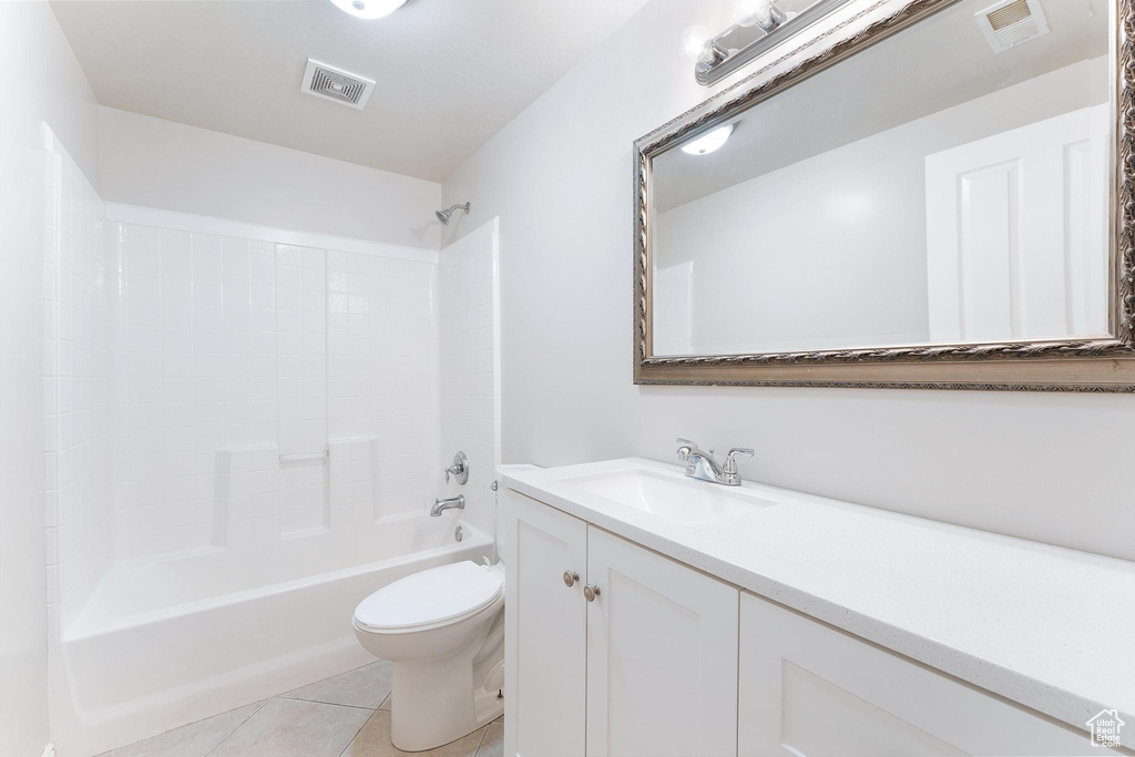 Bathroom featuring vanity, tile patterned floors, and shower / washtub combination