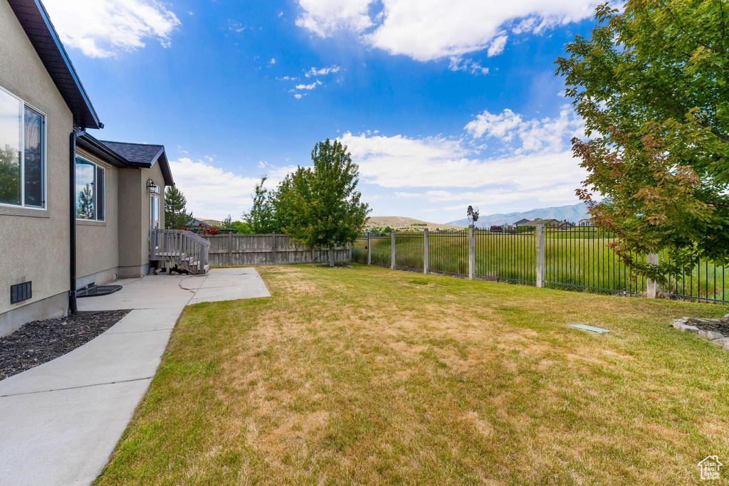Fenced backyard featuring a mountain view