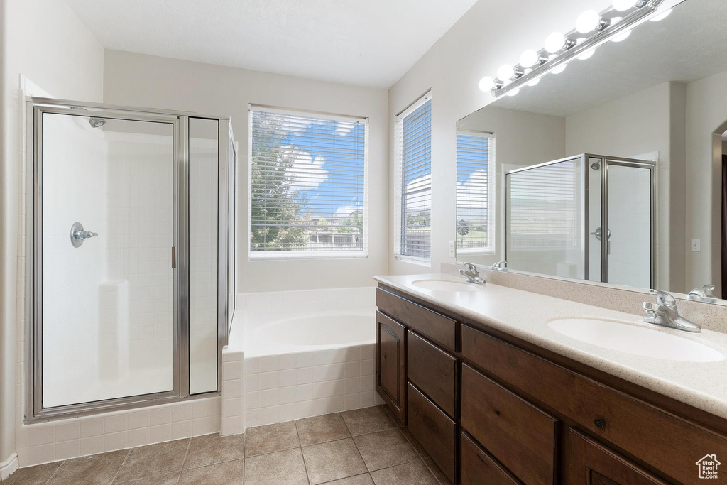 Full bathroom with a shower stall, double vanity, a bath, and tile patterned flooring