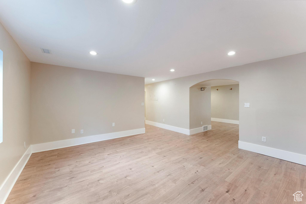 Spare room featuring arched walkways, recessed lighting, and light wood-type flooring