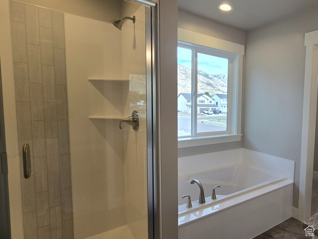 Bathroom featuring healthy amount of natural light, a stall shower, a bath, and recessed lighting