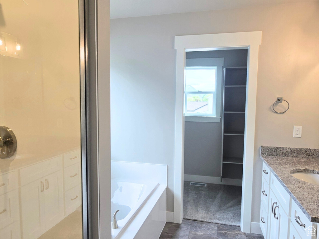 Bathroom with vanity and a bath