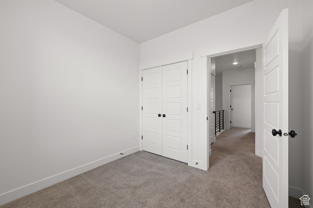 Unfurnished bedroom with carpet flooring and a closet