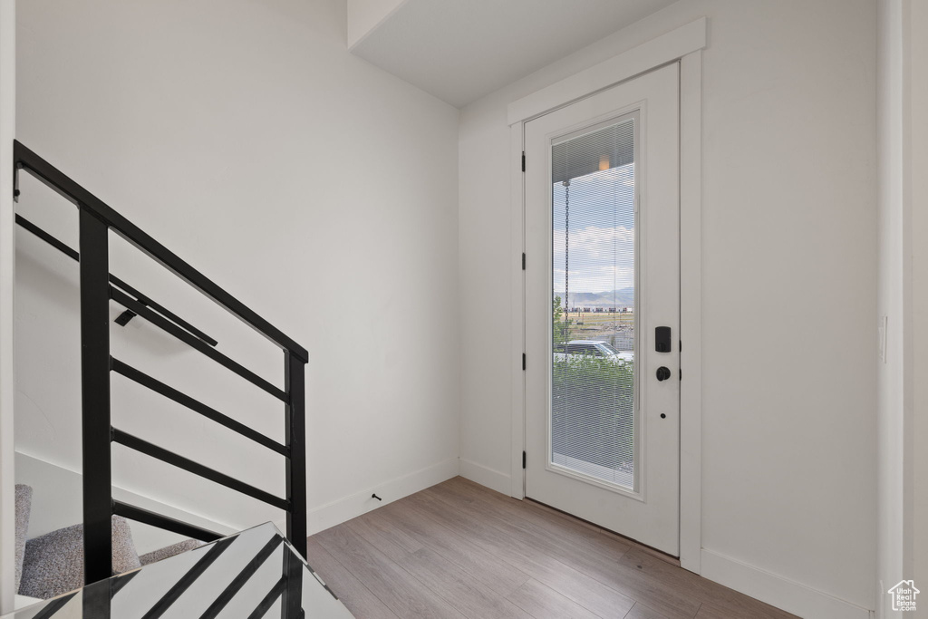 Foyer with light wood-style floors and stairway